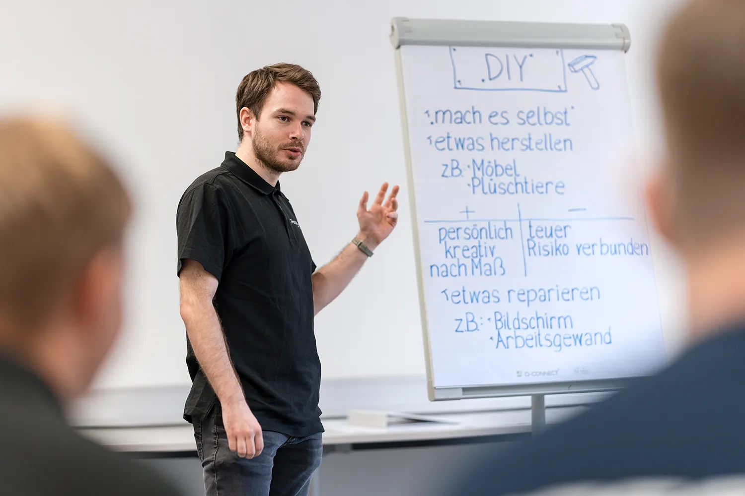 Lehrling präsentiert am Flipchart und trainiert sicheres Auftreten im praxisnahen Präsentationstraining.