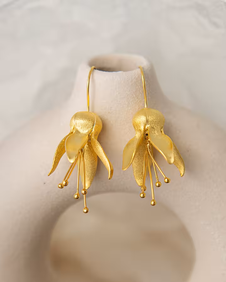Pendientes de flor de campana en oro mate, foto ambientada - Joyería Cayou