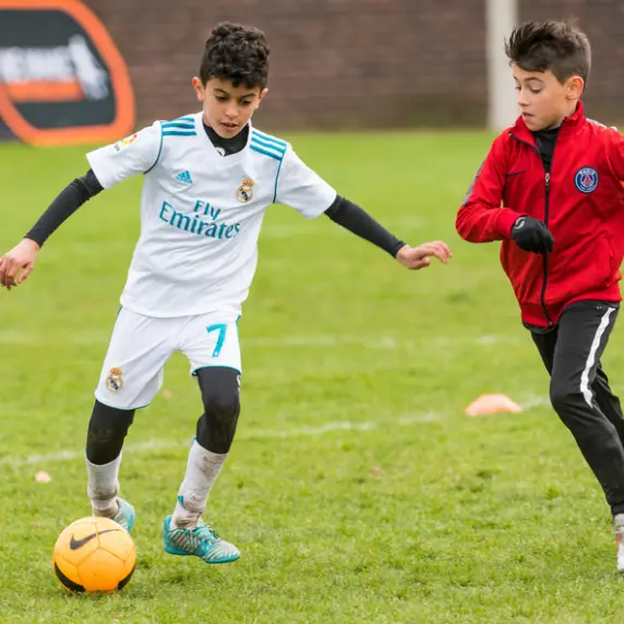 Two young soccer players competing on the field during training.