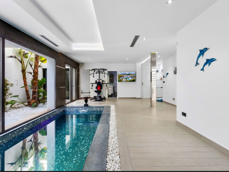 Indoor heated swimming pool and fully equipped gymnasium in luxury villa spa zone - professional fitness equipment