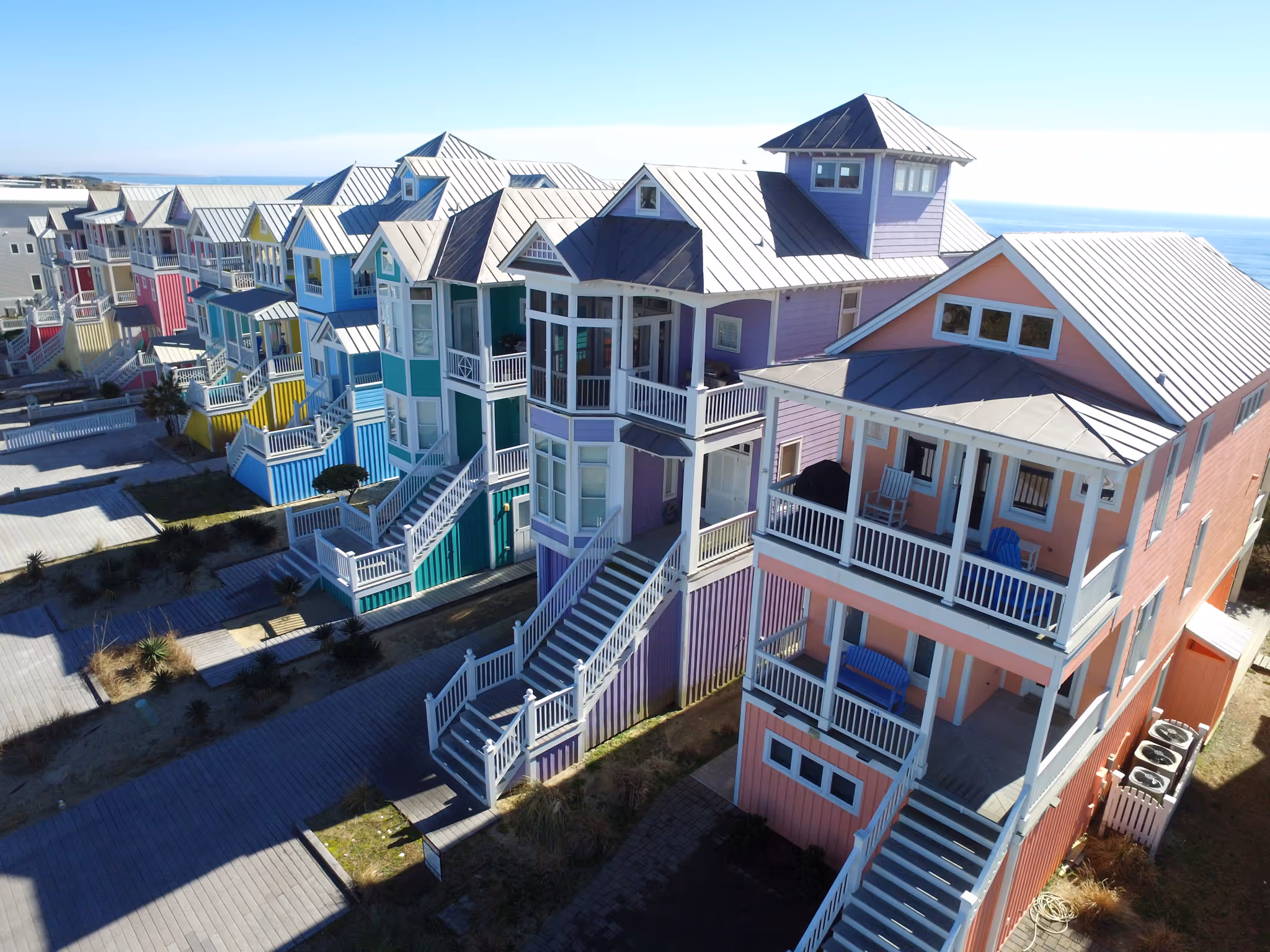 drone photo of beach front houses of various colours (similar to rainbow row) on the coast of north carolina