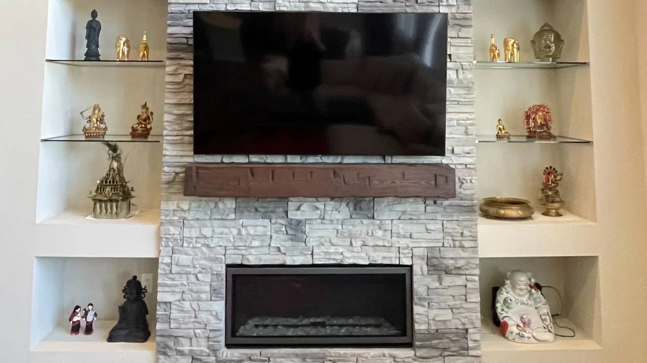 75-inch TV mounted above stacked stone fireplace in Plymouth Minnesota near Wayzata High School