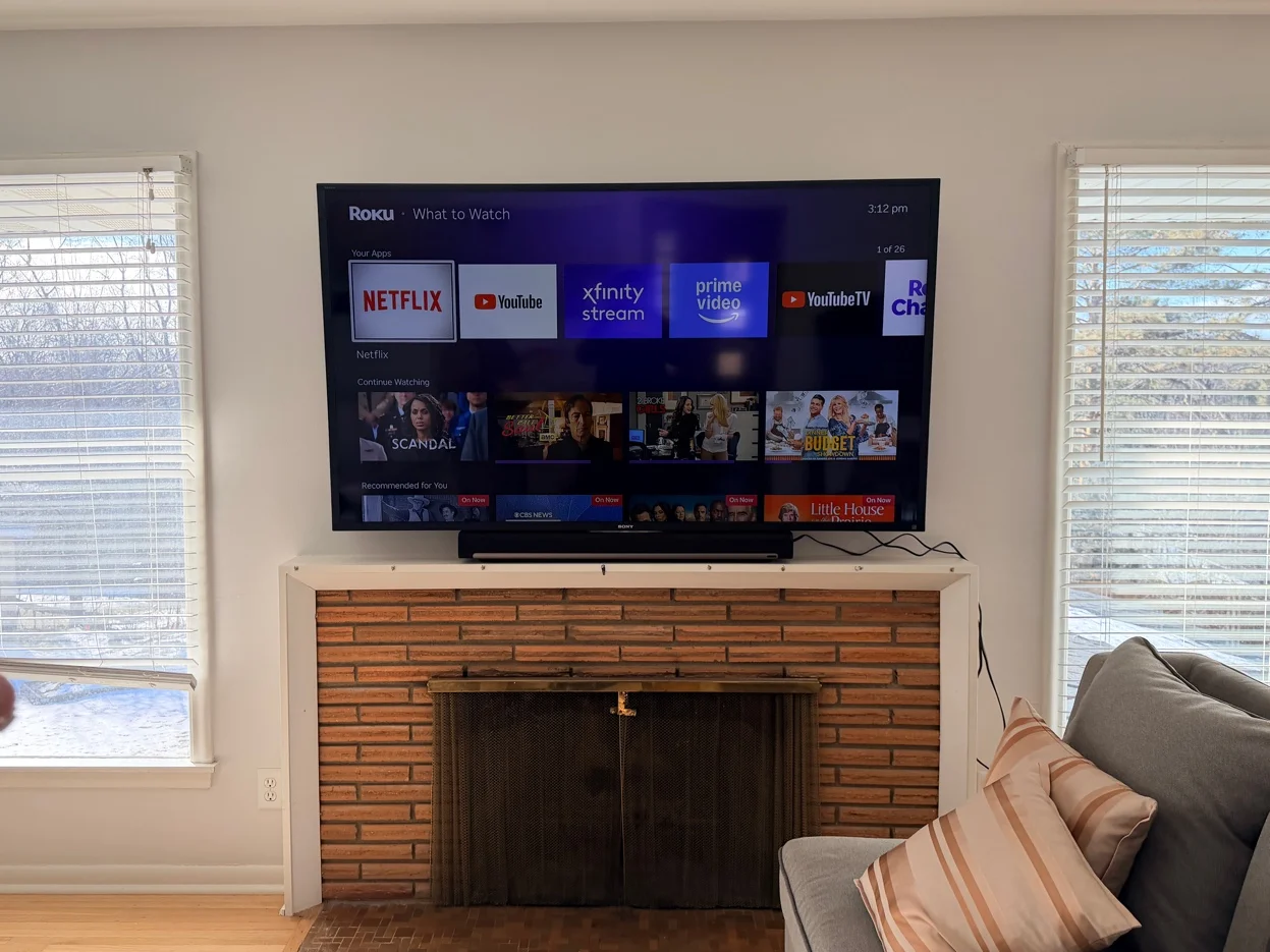 70-inch Sony TV with full-motion bracket mounted above brick fireplace in Edina