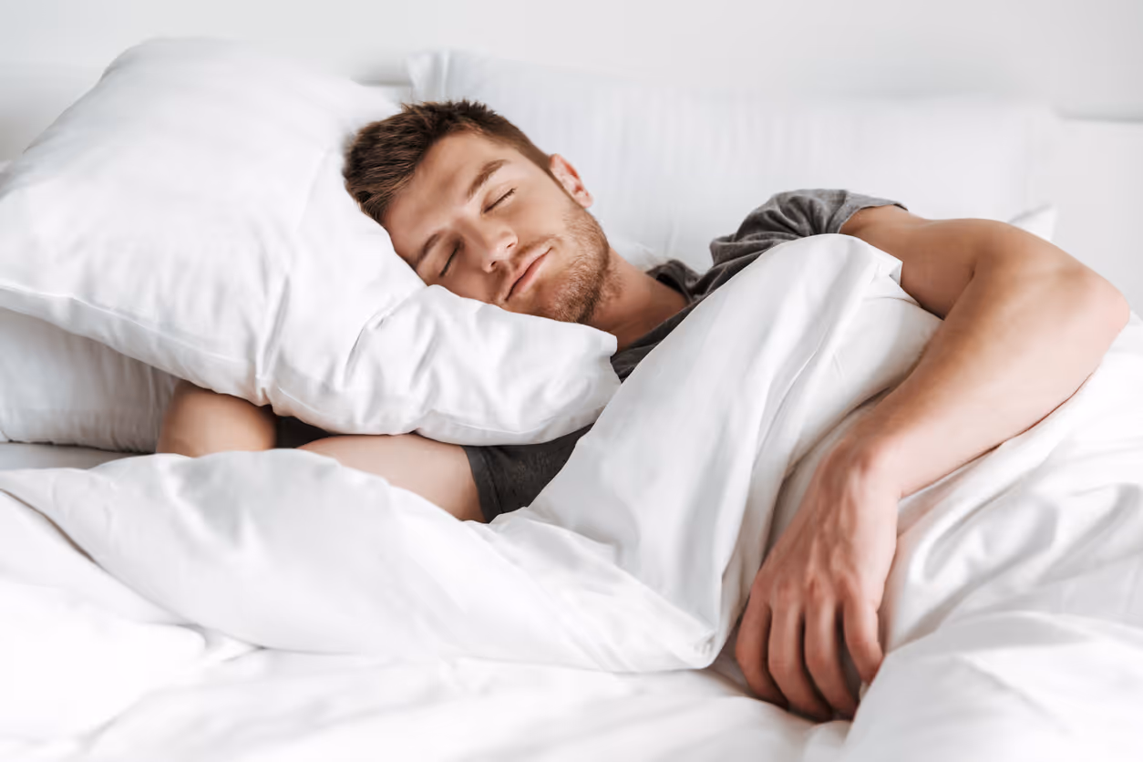Man sleeping well in comfy bed after training himself how to fall asleep faster