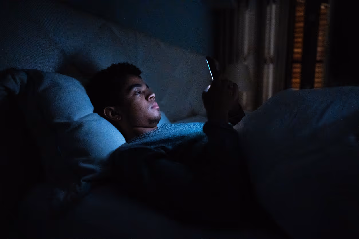 Man in bed looking at phone