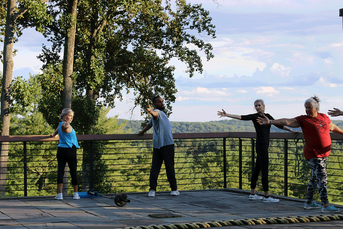Trainer Nick Rainey performing a stretch with his group class