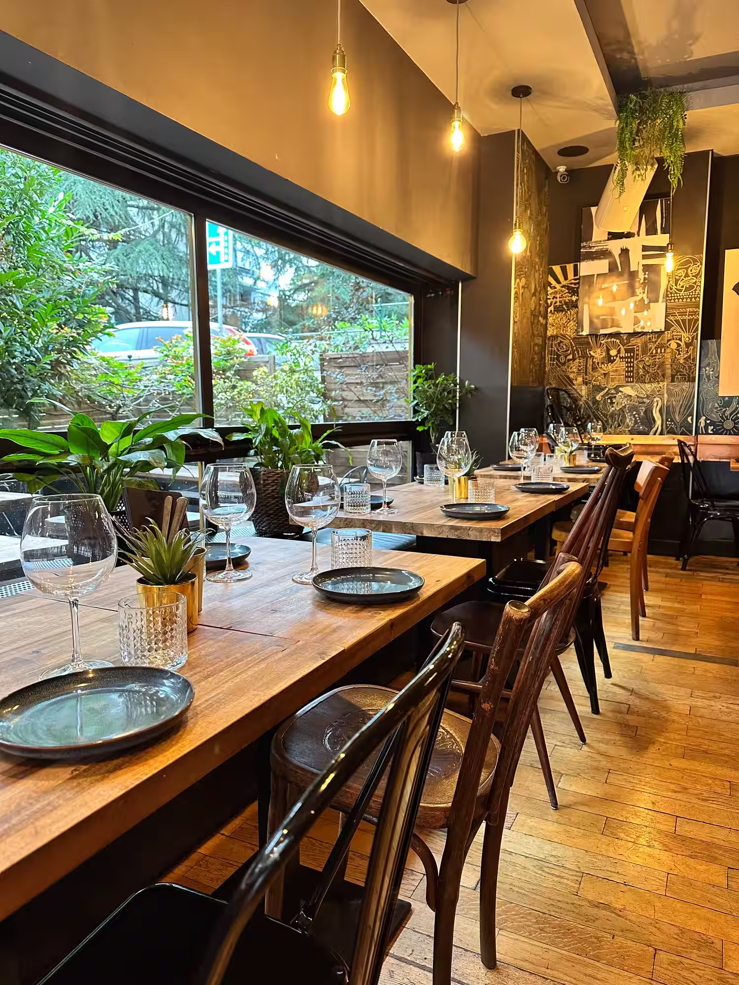 Salle intérieure chaleureuse du restaurant Le Jules-Édouard avec tables en bois
