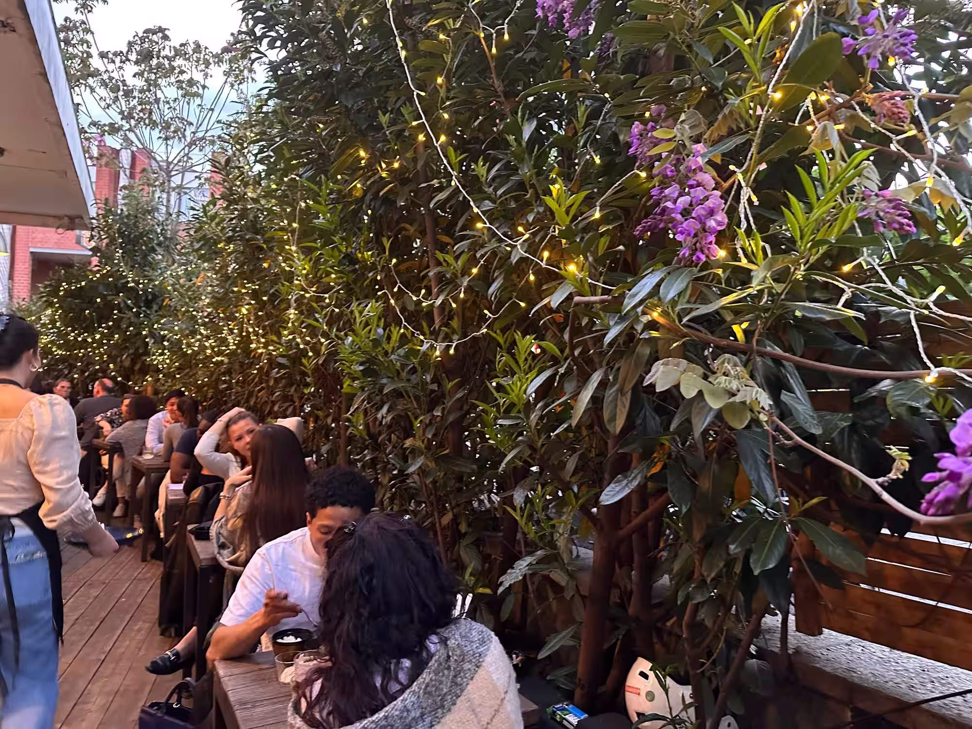 Terrasse conviviale du restaurant Le Jules-Édouard, ambiance chaleureuse en extérieur avec tables dressées et végétation