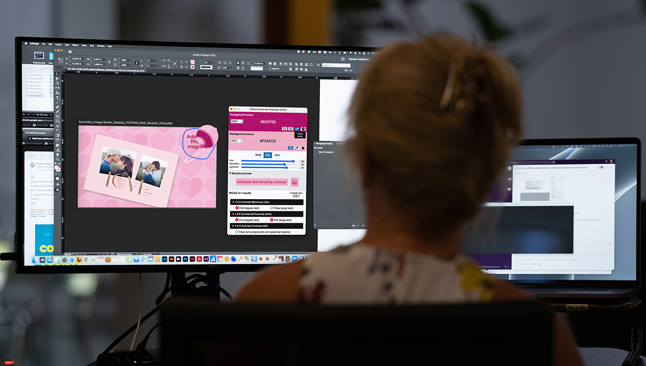 Person sitting at a desk working on a dual-monitor setup.
