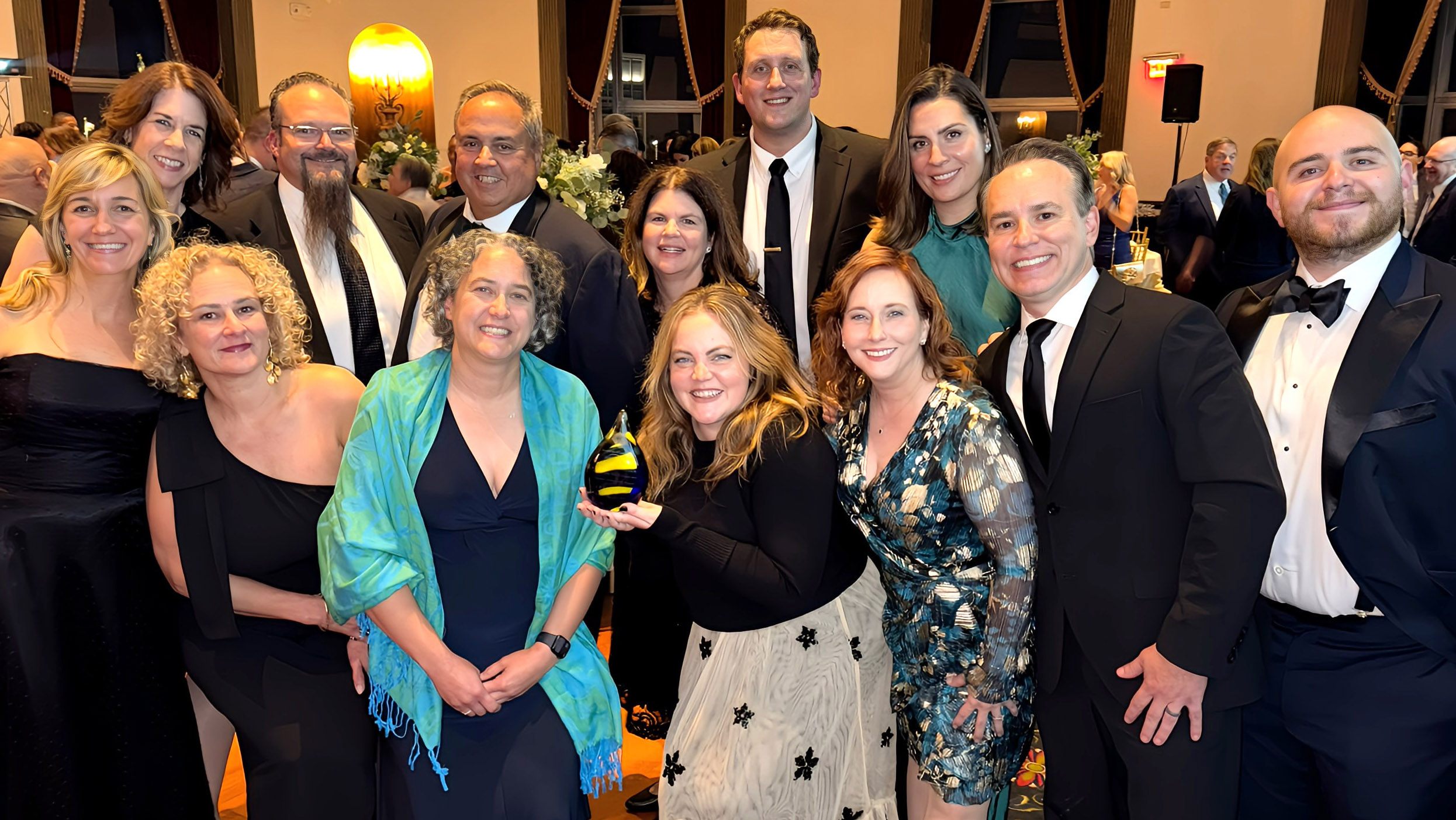 Group of people dressed formally posing together at an award event.