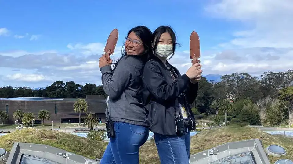 A diverse group of smiling teenagers working together in a professional community environment, representing local youth employment and leadership opportunities in the Bay Area.