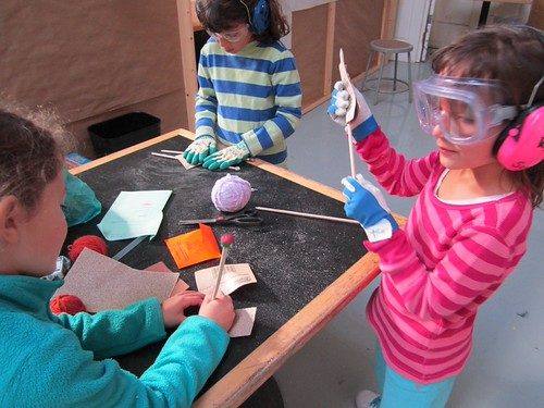 Brightworks School students in safety goggles building a project in the workshop