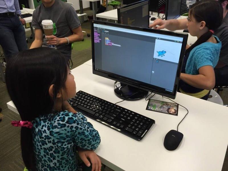 A Code Ninjas instructor helping a student with a laptop in Pleasanton, California