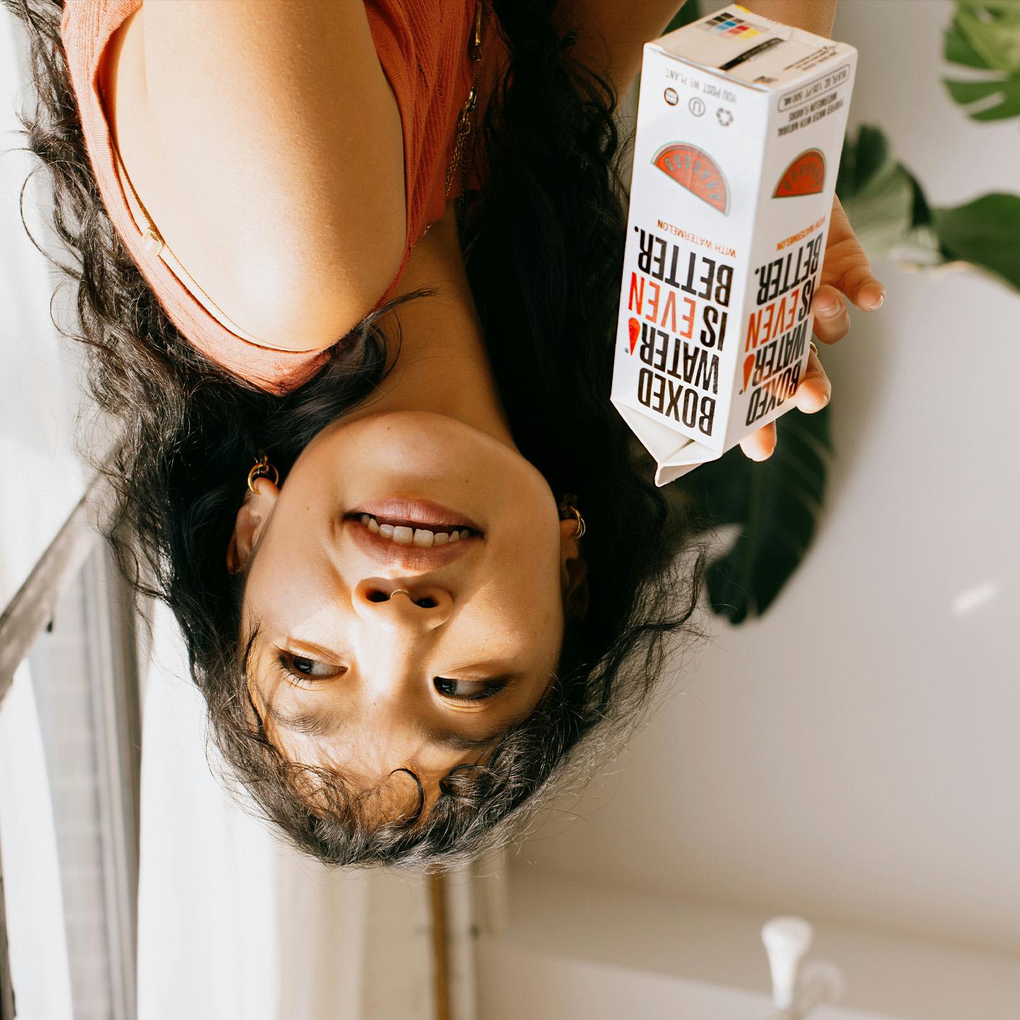 Creator posing with Boxed Water carton