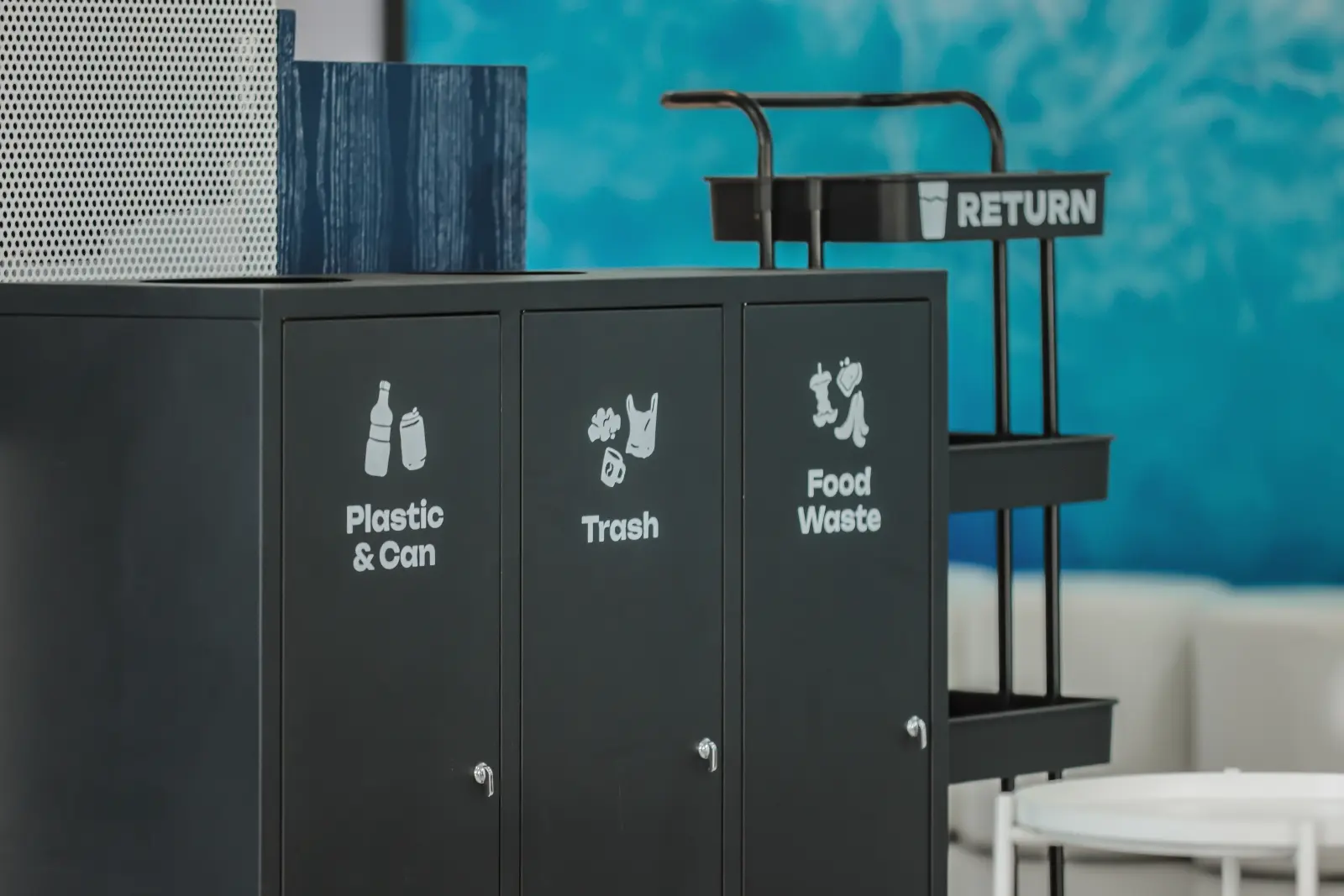Three labelled sorting bins at the Andaman Surprise lounge for plastic and cans, trash and food waste