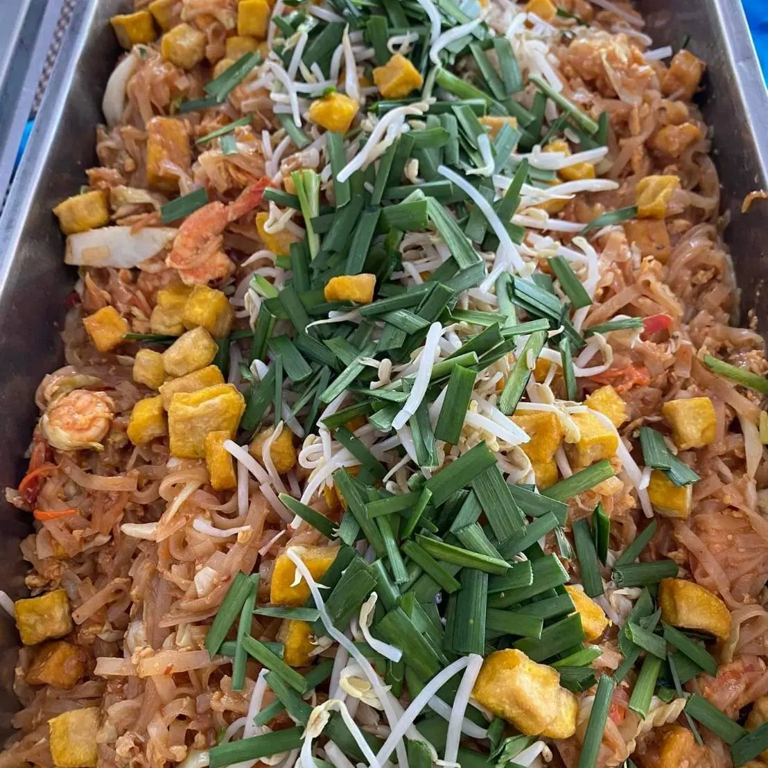 Pad Thai with shrimp, tofu, bean sprouts, and garlic chives served in a large tray.