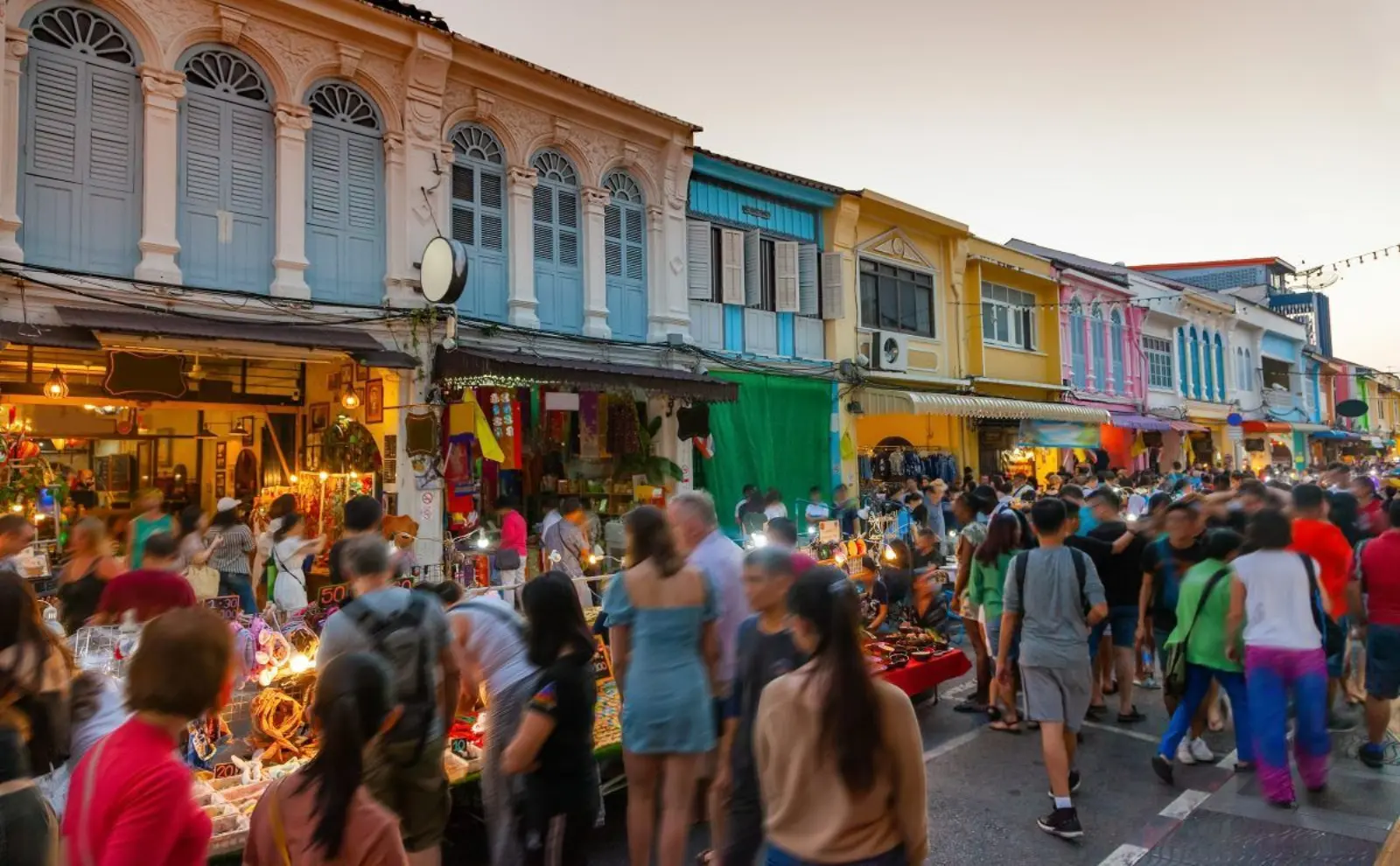 Phuket Old Town night market with crowds browsing street stalls among colorful Sino-Portuguese heritage buildings.