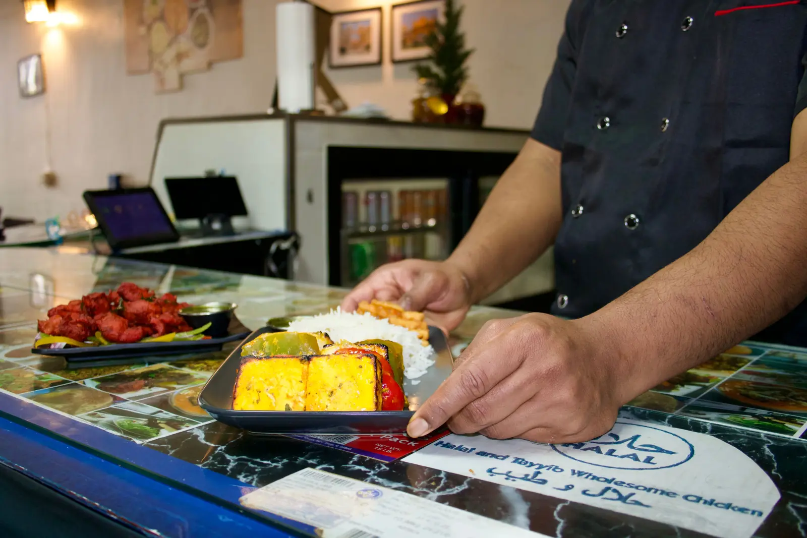 Halal restaurant serving grilled paneer, rice, and other halal dishes at the counter.