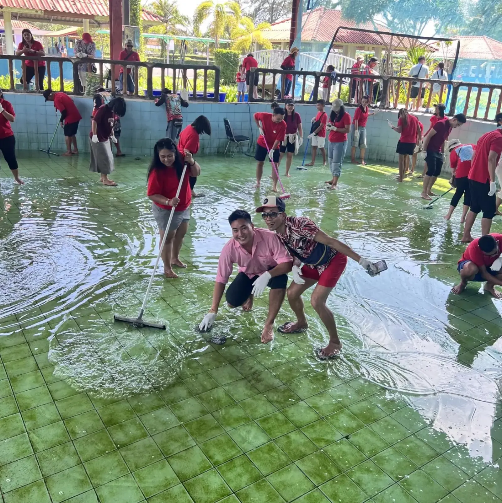 Volunteers cleaning turtle pools barefoot and in gloves at the Sea Turtle Conservation Centre at Phang-nga Naval Base.