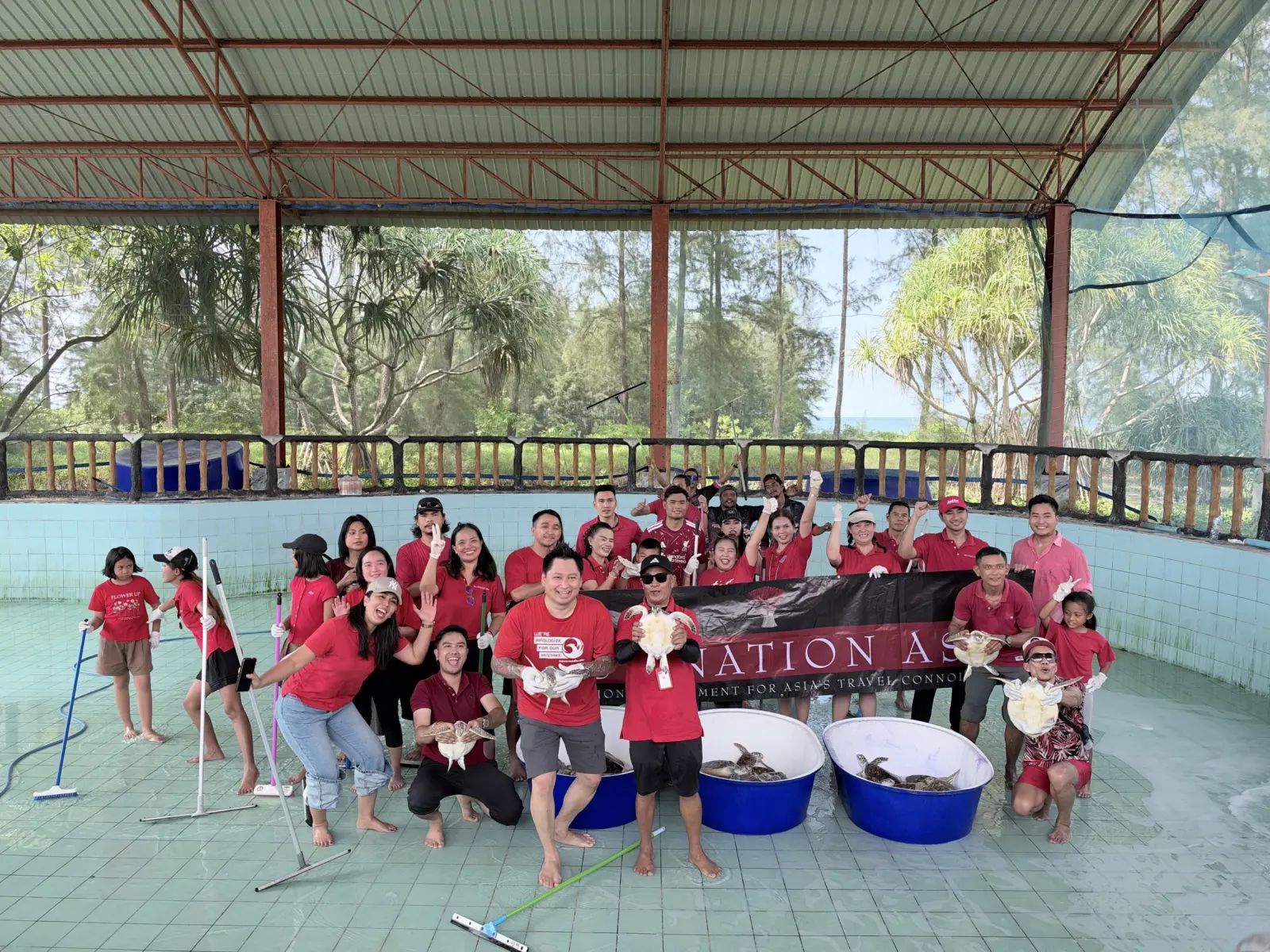 Volunteers with sea turtles at the Sea Turtle Conservation Centre at Phang-nga Naval Base during a conservation activity Andaman Surprise with Destination Asia.