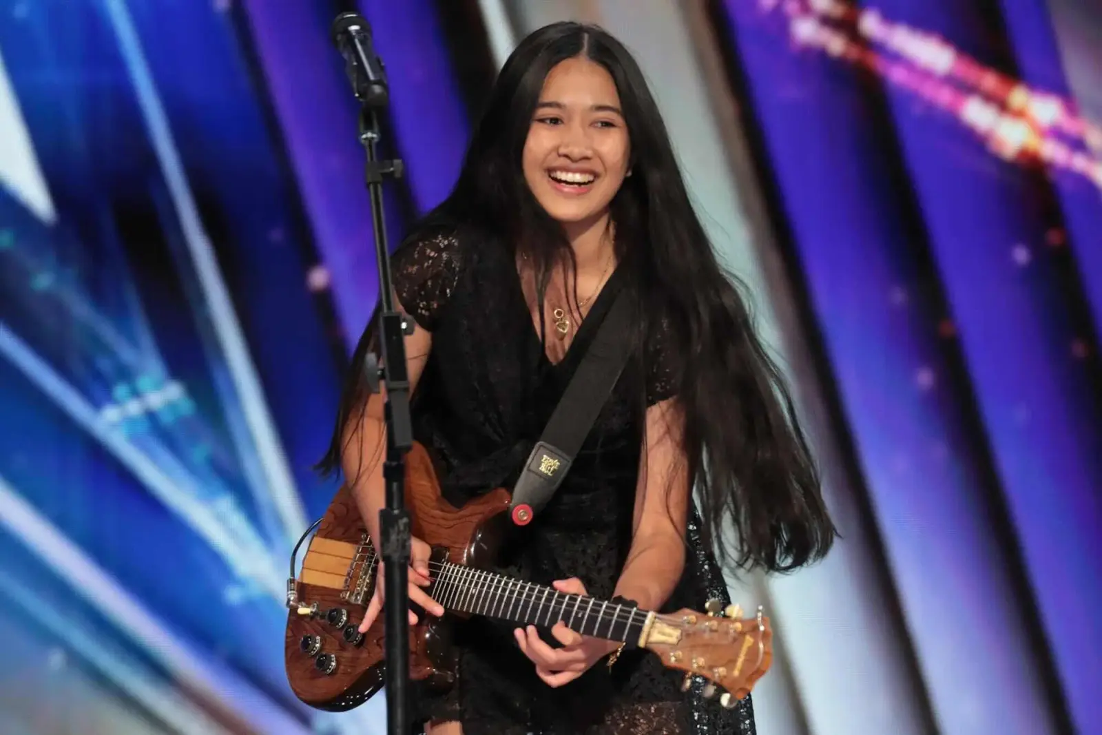 Nene Royal smiling while performing electric guitar onstage during America’s Got Talent.