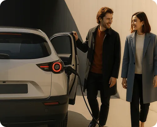 A couple standing on the site of a charging EV
