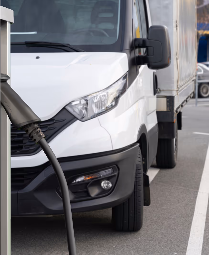 Electric delivery van charging at EV station.