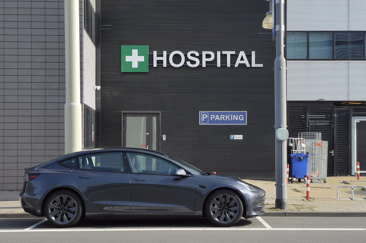 Electric car parked outside hospital building.