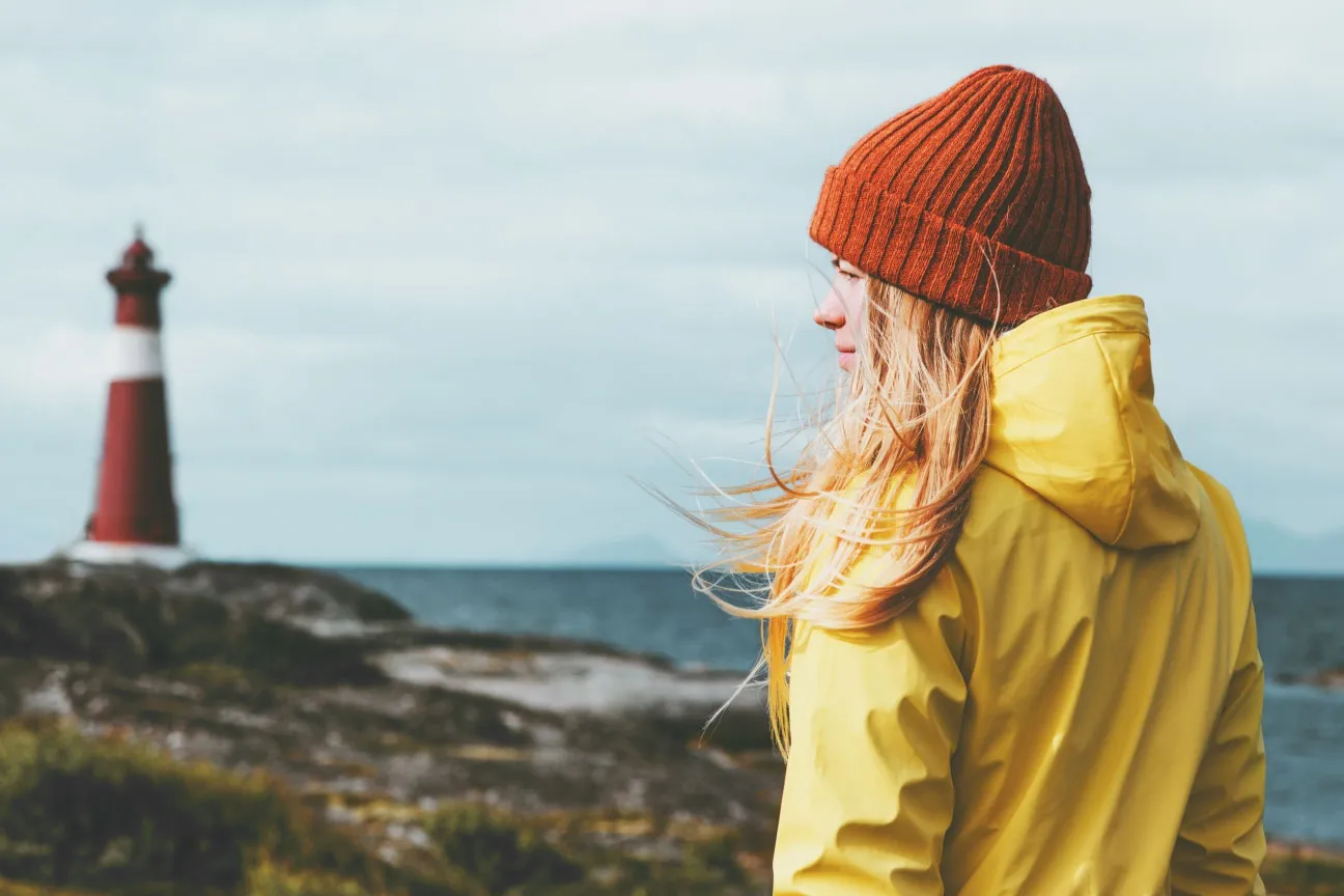 A girl with cap standing on mountain