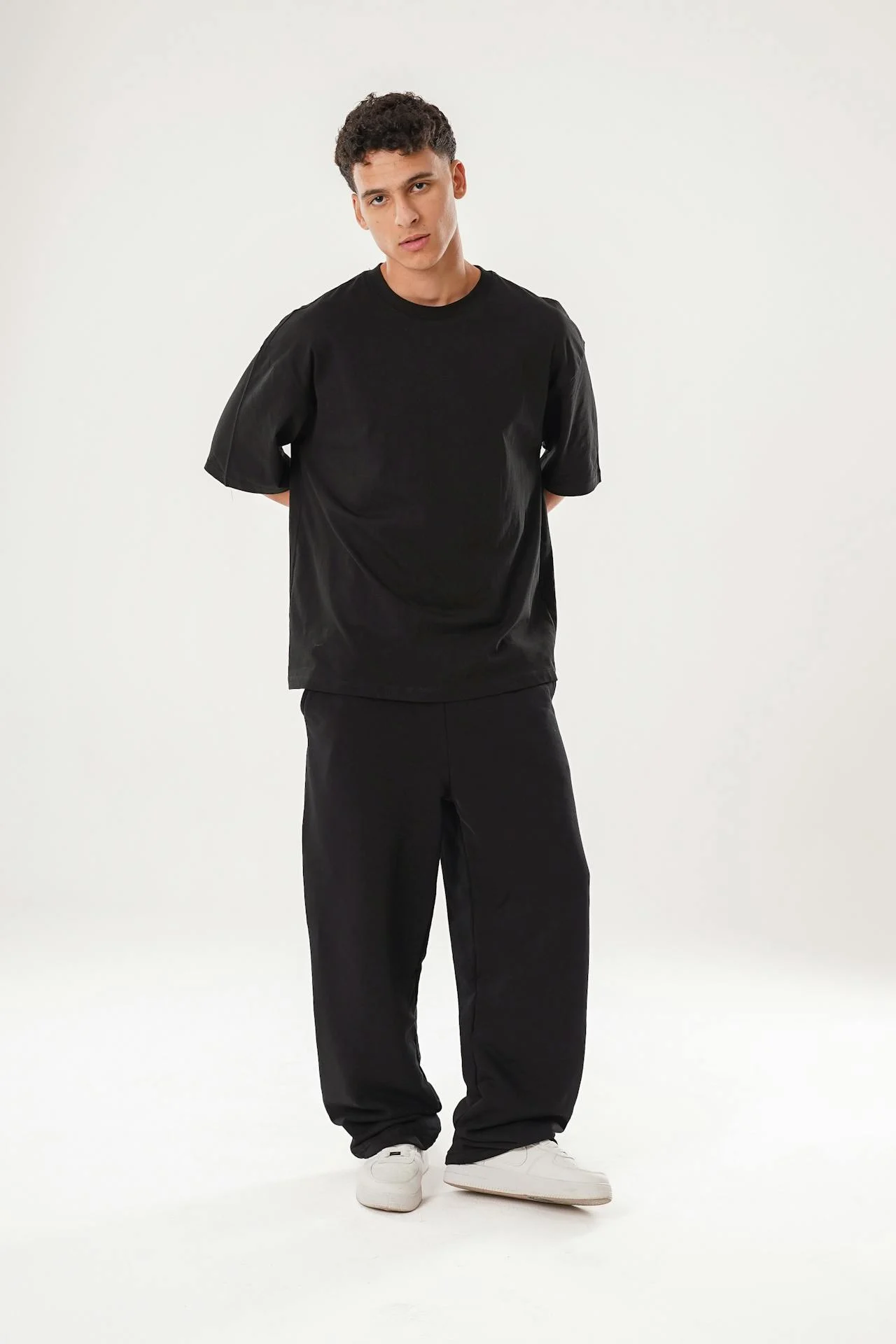 Man showcasing black Sinners tracksuit in full outfit
