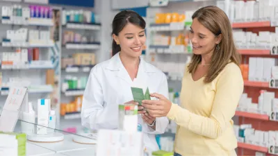 Apothekerin berät Kundin zu einem Medikament in einer Apotheke.