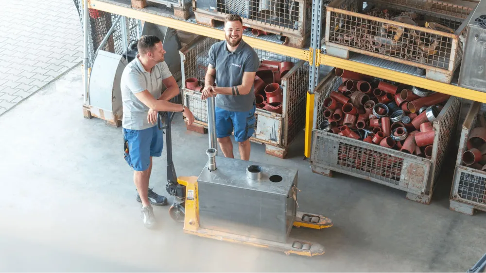 Foto von Lagerhalle mit zwei Mitarbeitenden der BROCHIER Gruppe