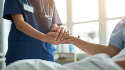 MFA hält Hand von Patient:in