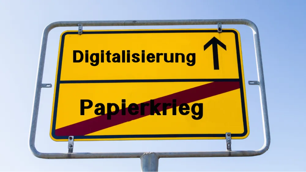 Ortsschild, wo Papierkrieg durchgestrichen ist und Digitalisierung die Richtung anzeigt