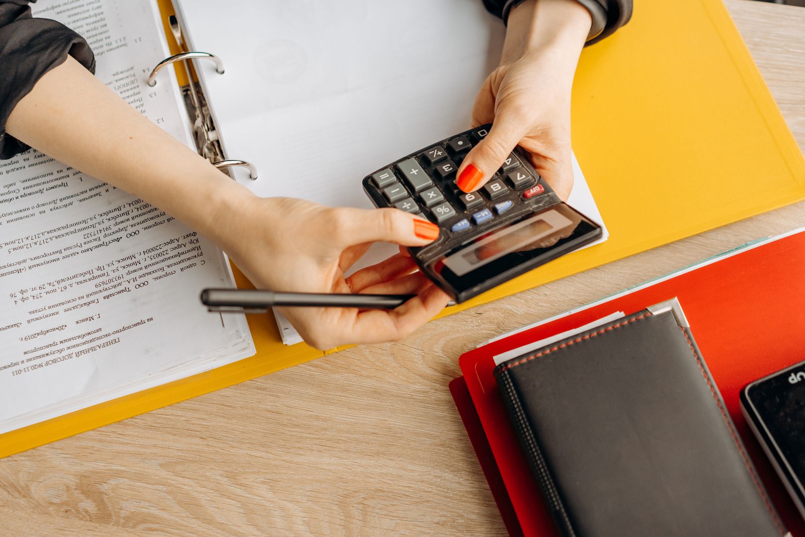 Person working out costs with a calculator and documents