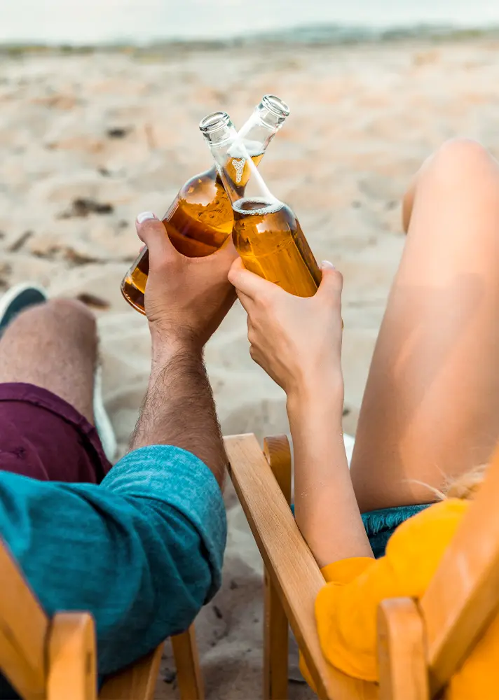 Ferien Freunde am Strand genießen ein kühles Getränk. 
