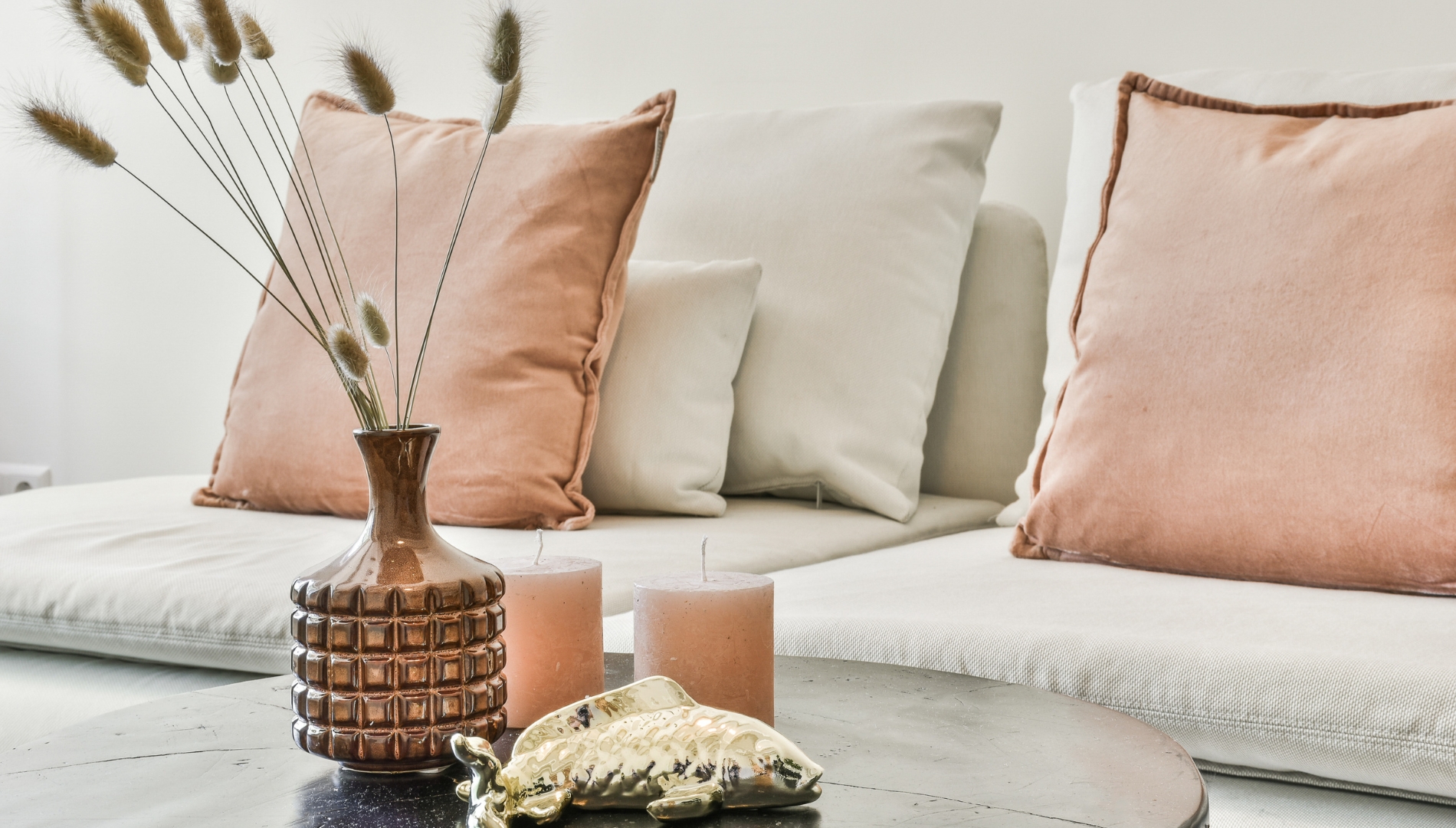Close-up of a modern rental property interior featuring neutral-toned cushions, a decorative vase with dried grasses, and soft lighting—showcasing the style and comfort of a well-presented buy-to-let investment.