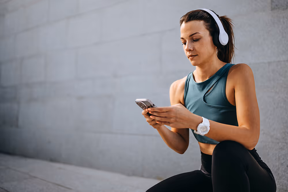 Woman checking the LIFEHACKR App while working out.