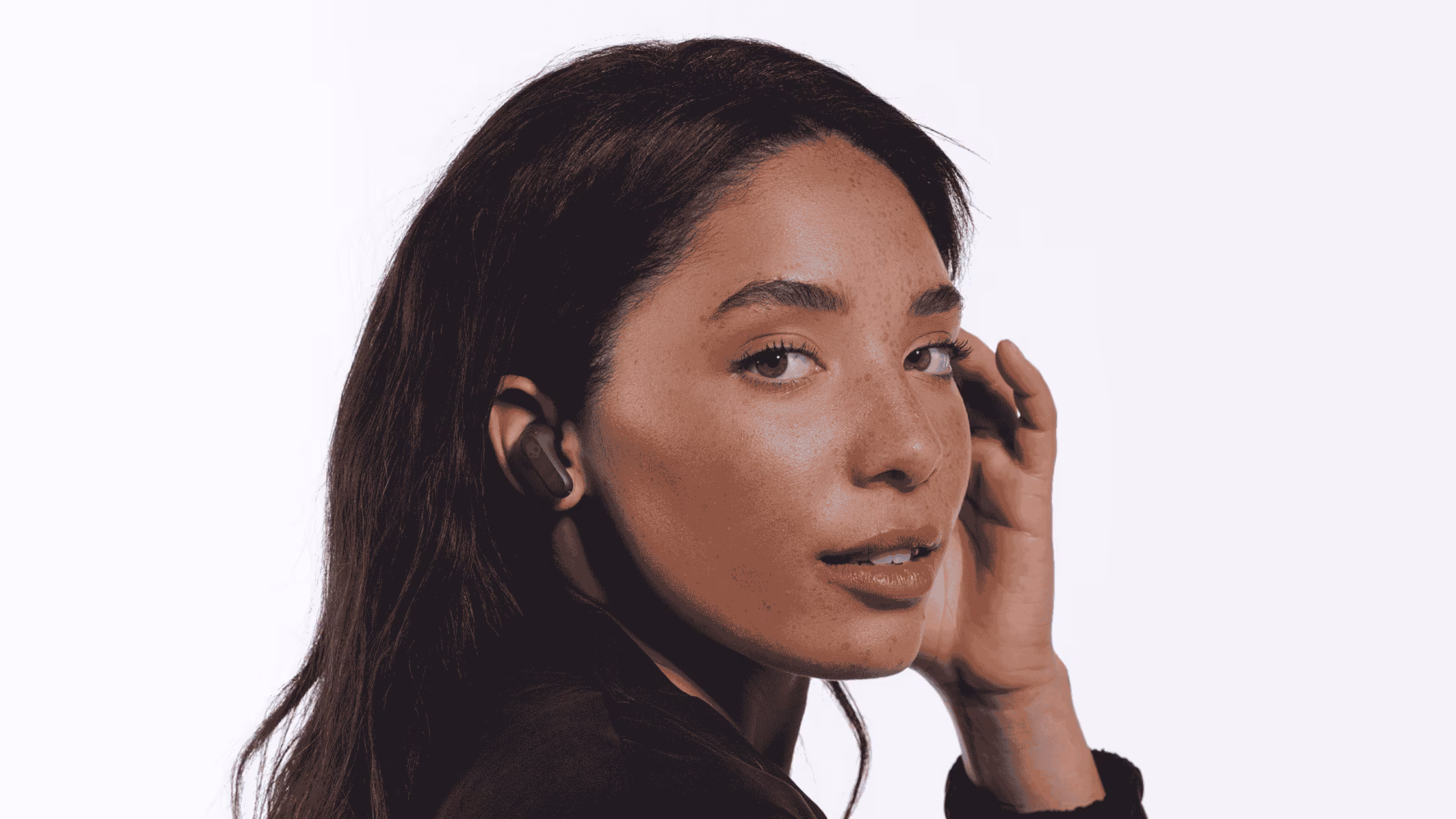 A person wearing a Skullcandy Rail ANC TWS earbuds in front of a white background