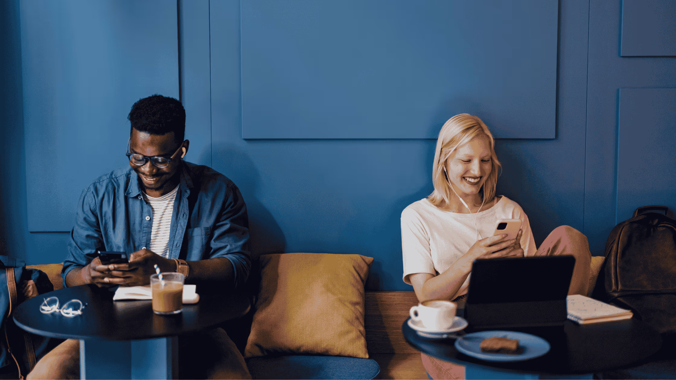 three people sitting in a coffee shop using their laptops