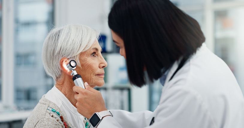 Senior citizen, doctor and otoscope for ears, hearing test and examination, audio check, or healthcare consultation. ENT, ENT doctor and doctor with elderly person for wellness in the hospital