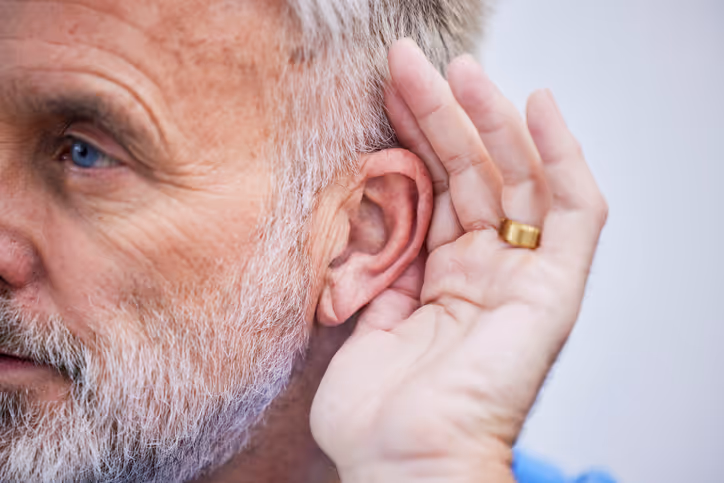 Man holding his ear to hear better