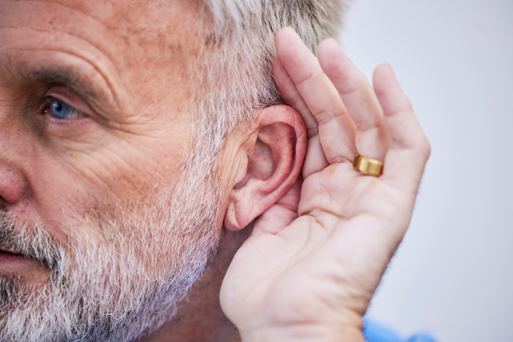 Man holding his ear to hear better