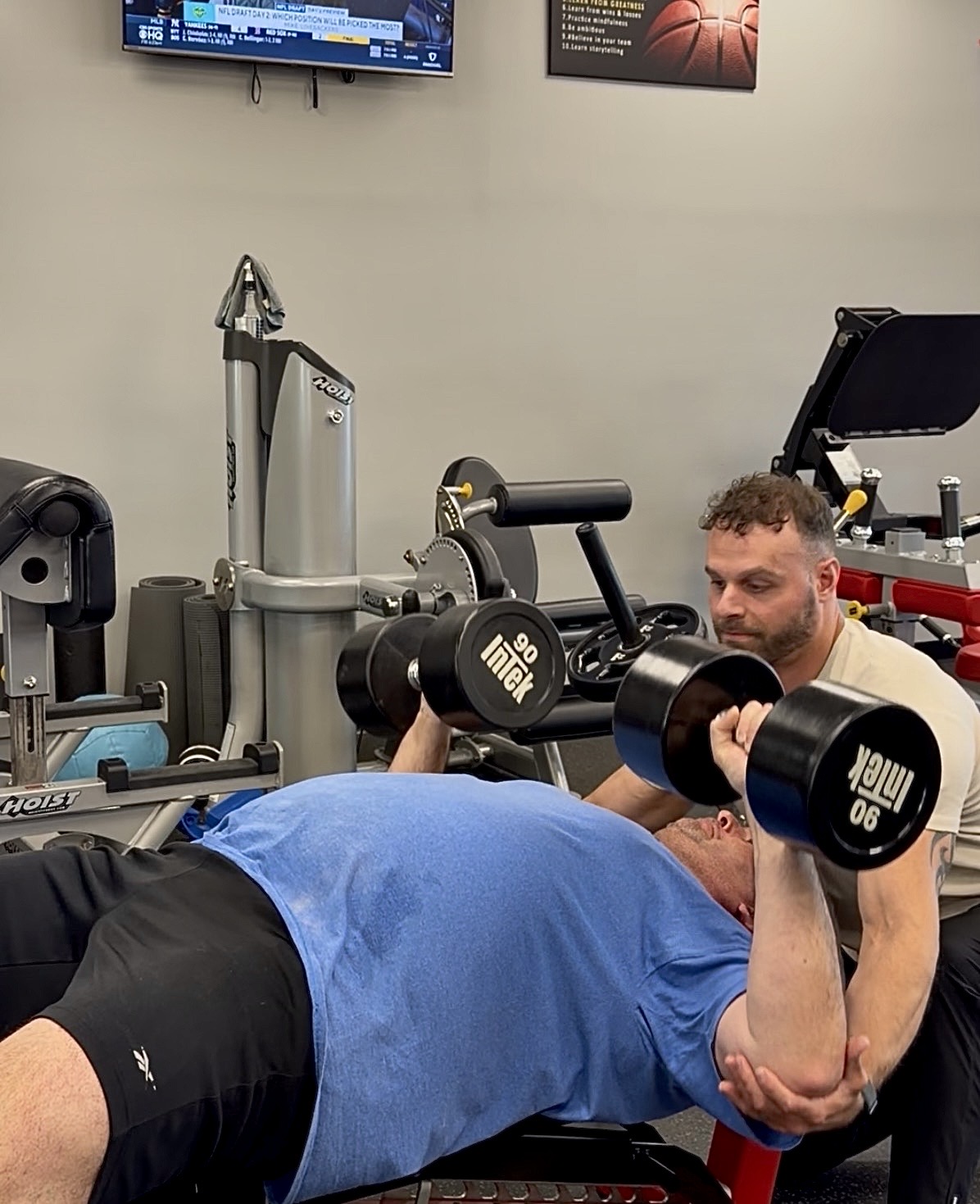 Lexington Kentucky personal trainer at DiPaola Training spotting client lifting 90 lb dumbbells during private one-on-one strength training session