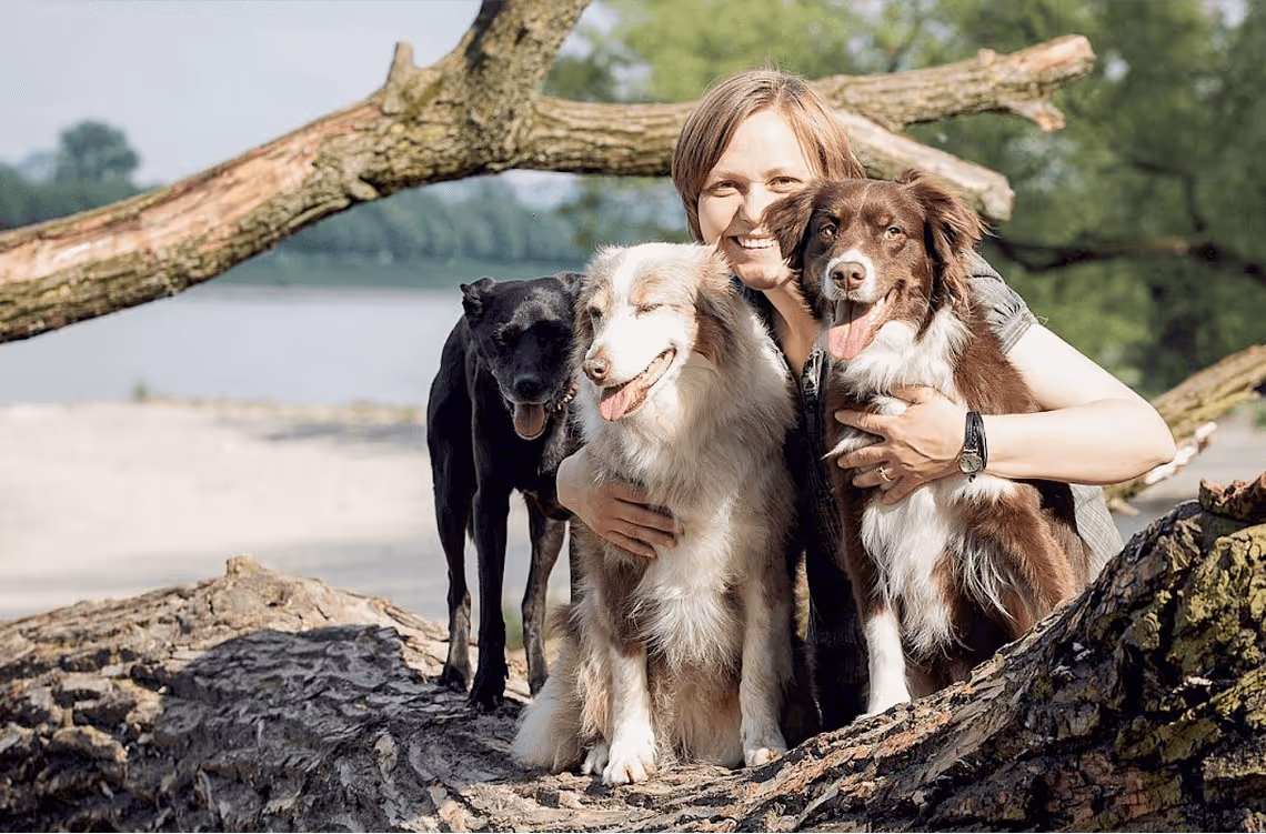 Frau mit zwei Hunden im Wald, ruhiger Moment