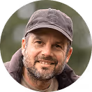 Mann mit Kappe, lächelt in die Kamera