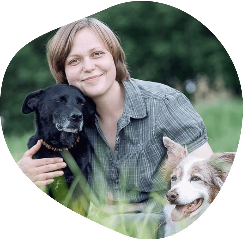 Frau mit schwarzem Hund auf Wiese, Portrait