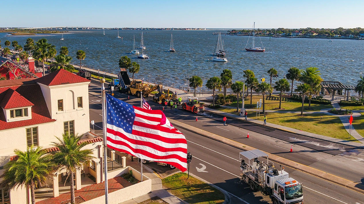 American flag flying over the Jacksonville, Florida riverfront with a Duval Asphalt crew at work