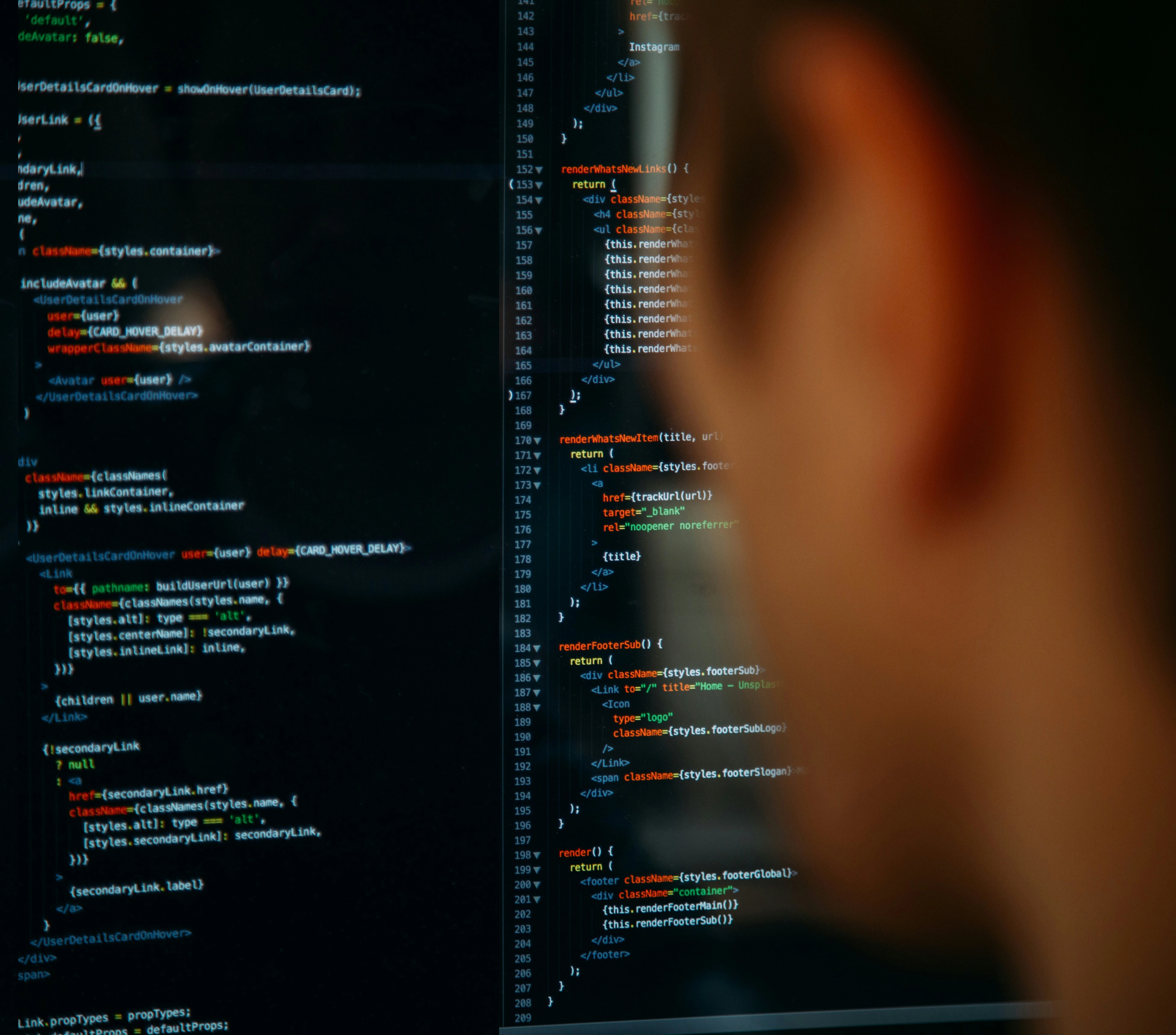 Une personne regarde un écran d’ordinateur affichant des lignes de code avec coloration syntaxique dans un éditeur de texte à thème sombre.