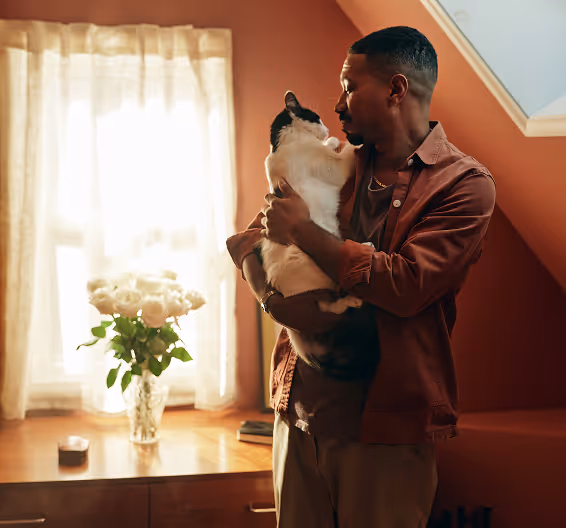 Red-haired woman working on a laptop at a table with a Dalmatian dog sitting beside her.